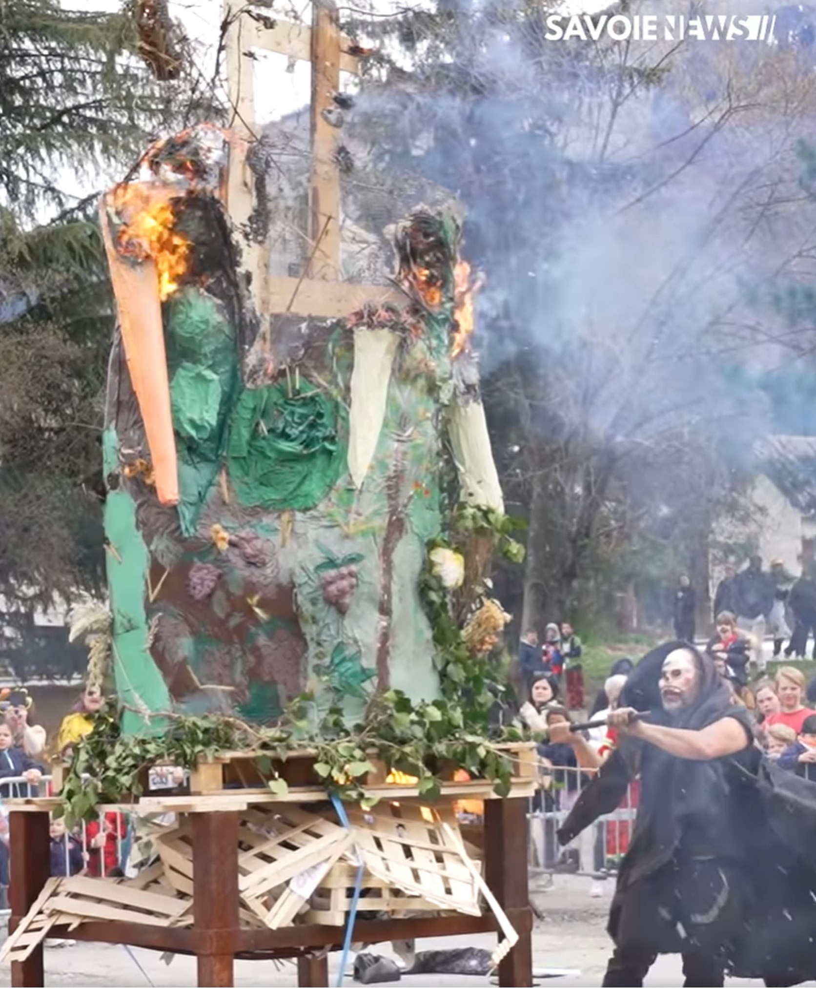 Artiste costumé devant un décor enflammé au carnaval de Saint-Jean-de-Maurienne