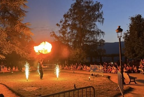 Artiste réalisant un effet de feu devant le public du festival La Tête dans les Étoiles à Albertville