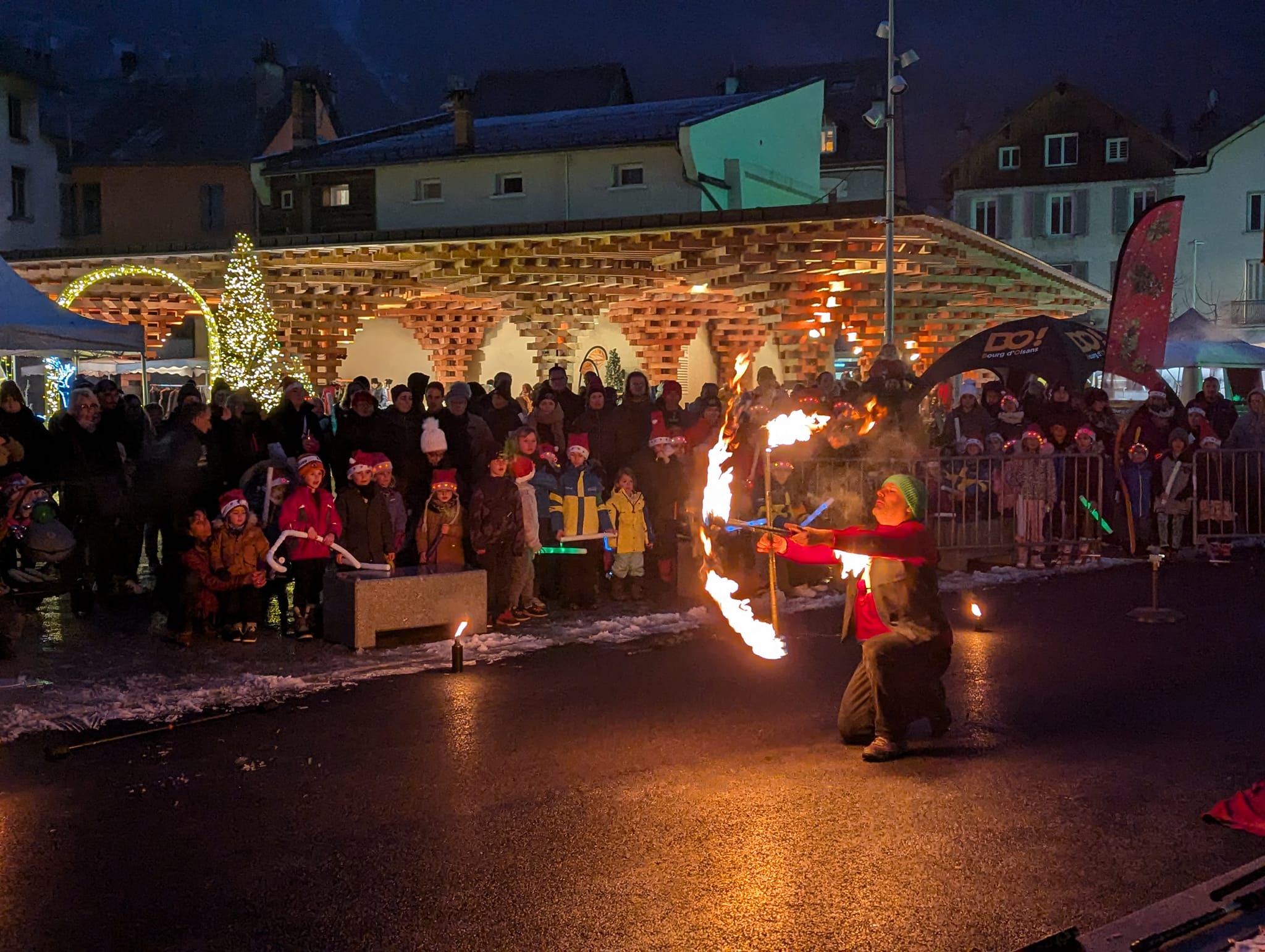 Jongleur de feu devant le public du marché de Noël à Bourg d'Oisans